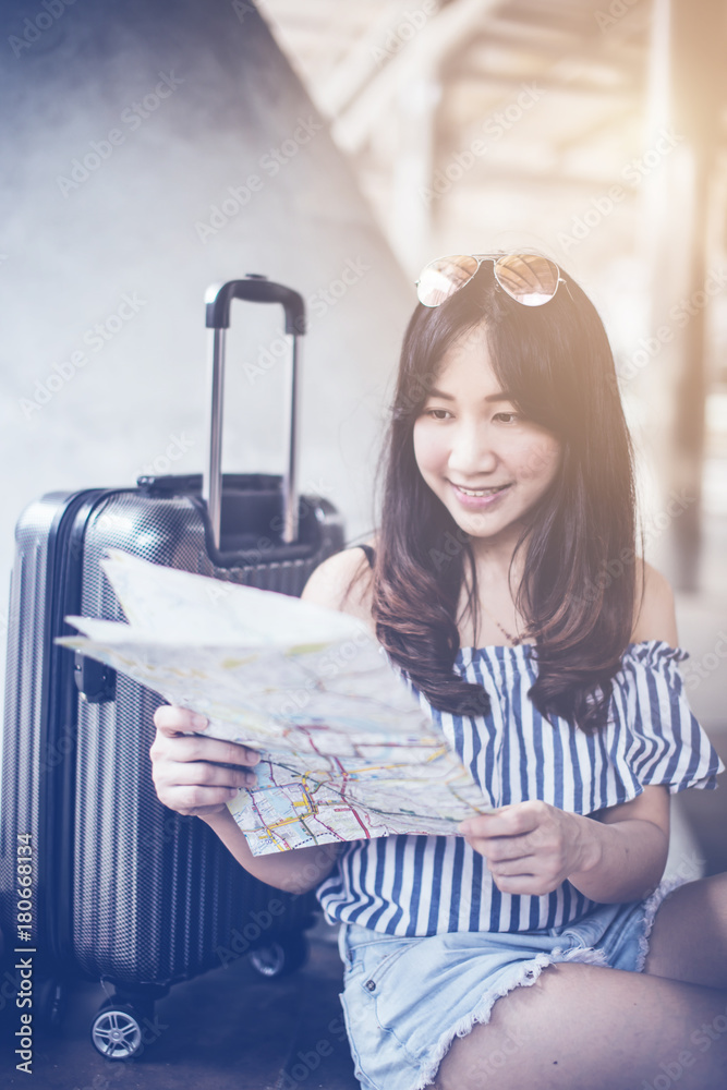 美丽幸福的年轻亚洲女孩穿着休闲服独自在火车站或机场旅行