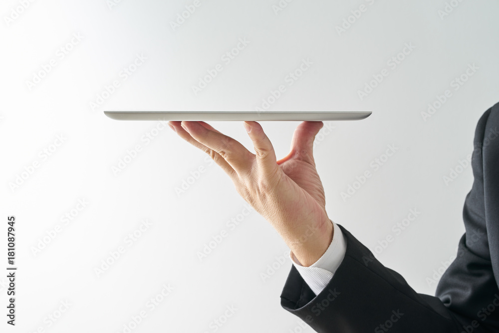 服务员手里拿着一个空的数字平板电脑，在白色背景上隔离。数字服务的概念