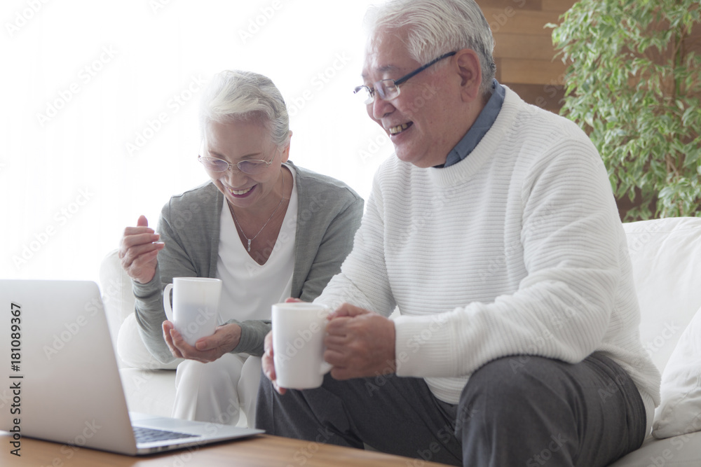 一对老夫妇一边喝咖啡一边练习电脑