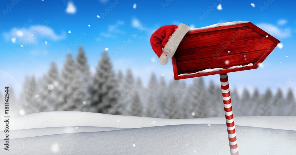 圣诞冬季景观和圣诞老人帽中的木制路标