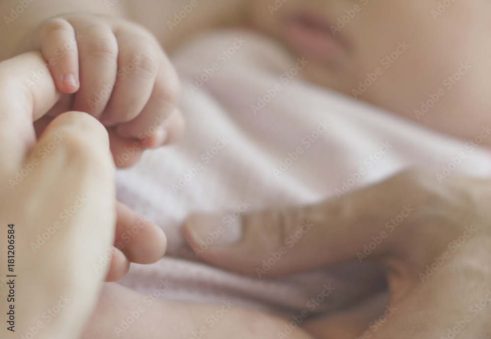 婴儿牵着母亲的手的特写