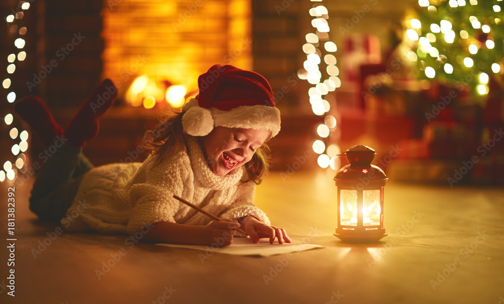 小女孩在圣诞树附近给圣诞老人家写信