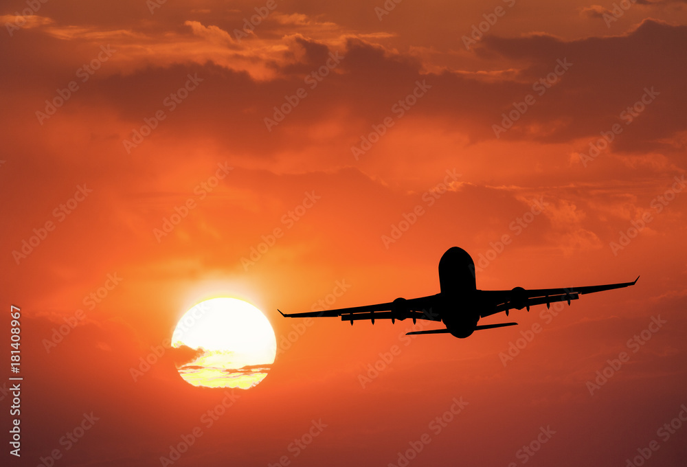 Silhouette of the aircraft and red sky with sun. Landscape with passenger airplane is flying in the 