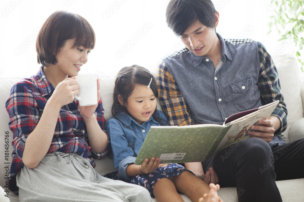 爸爸和妈妈正在给女儿读图画书。
