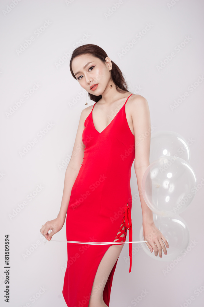 亚洲美女，穿着红色连衣裙，带着柔和的气球