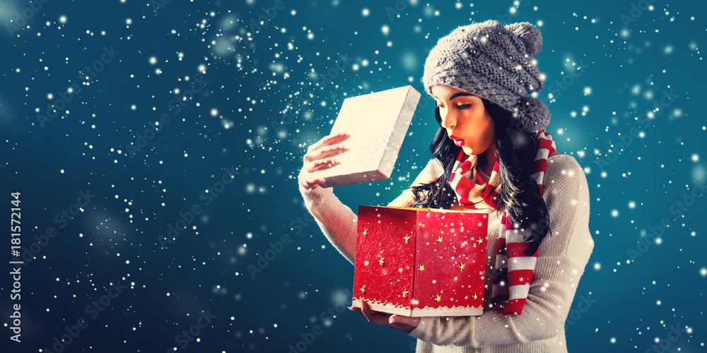 快乐的年轻女人打开圣诞礼物盒