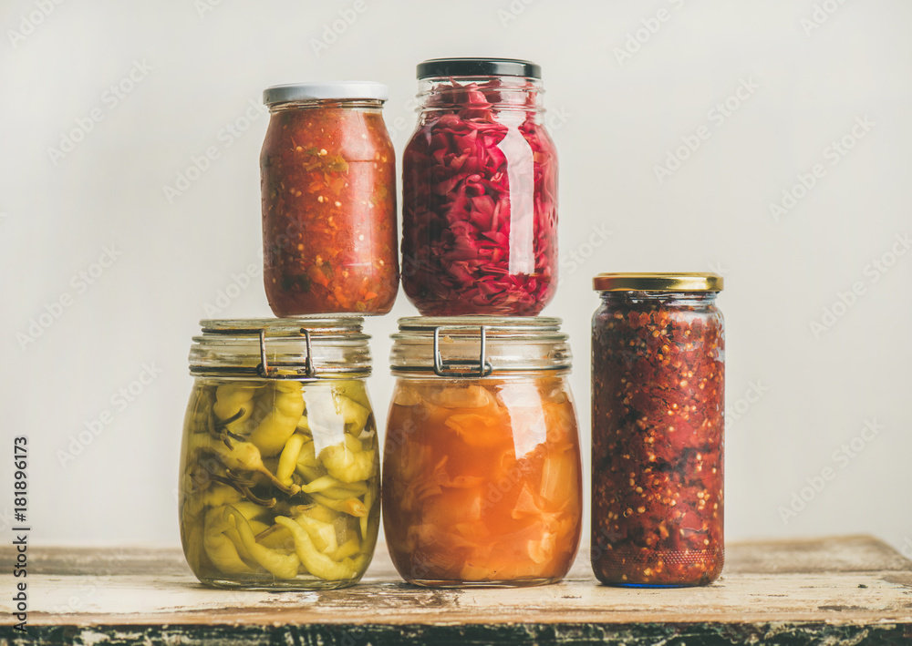 秋季时令腌制或发酵彩色蔬菜，装在玻璃罐中，叠放在年份上