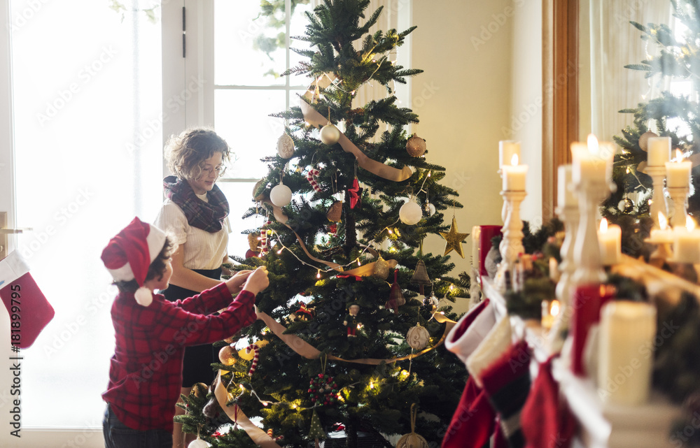 People decorating Christmas tree