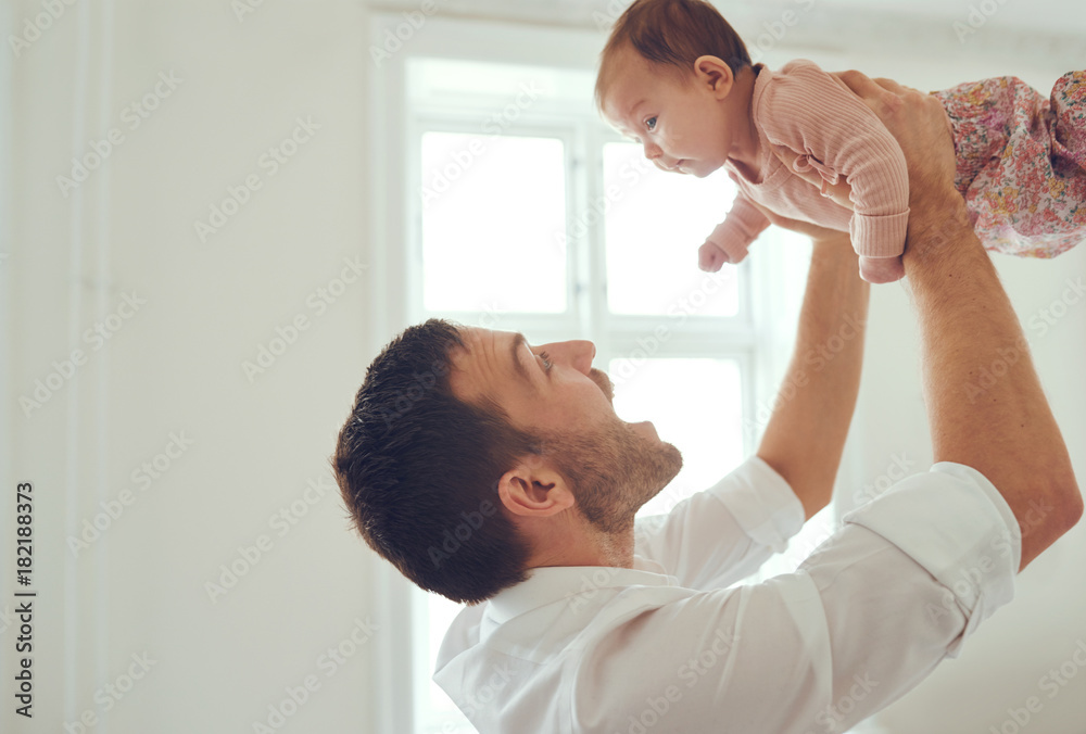 骄傲的父亲把他的女婴举在空中