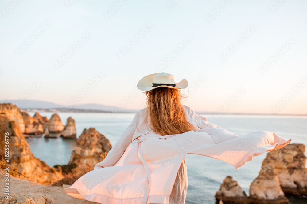 波图加南部拉各斯日出时，一名女子在岩石海岸线上欣赏美景