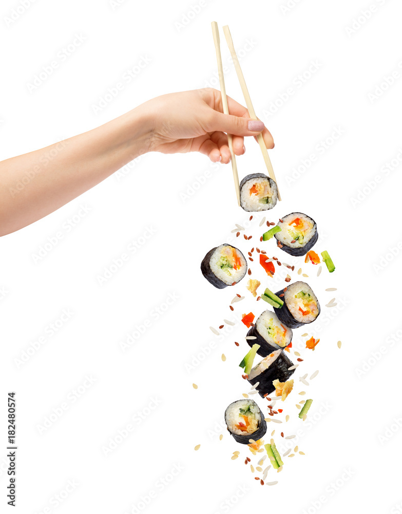 女性手中拿着木筷子，在白背上隔离掉下来的寿司和寿司卷