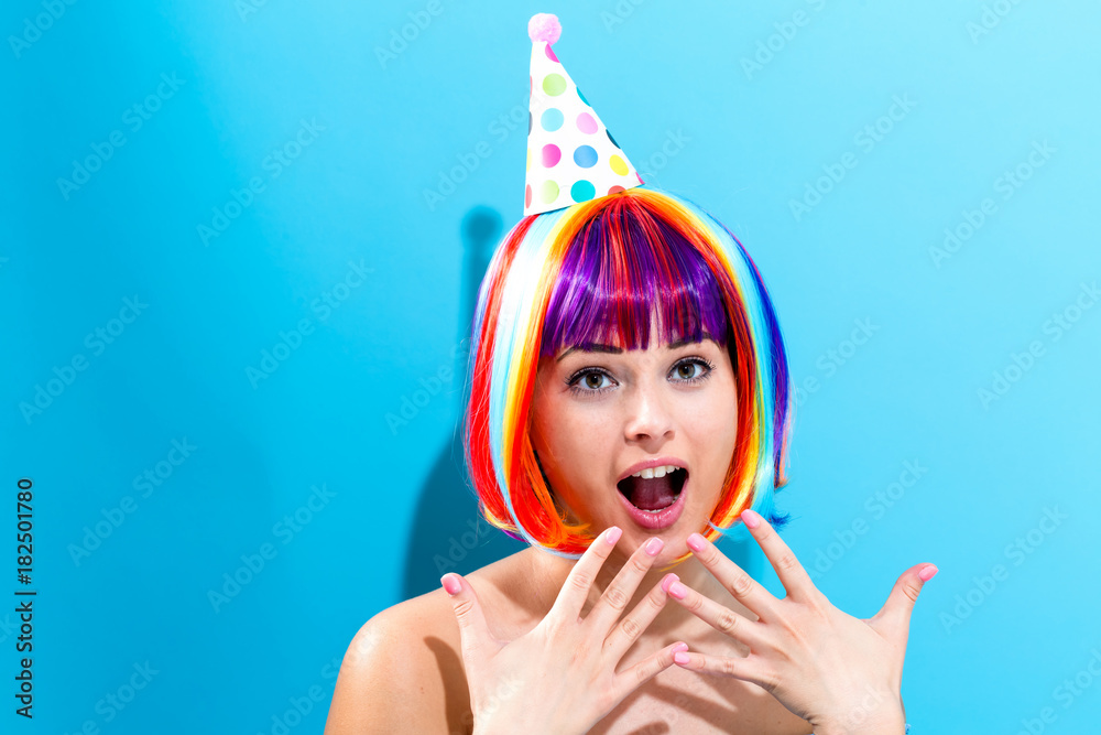 派对主题，蓝色背景下戴着彩色假发的女人