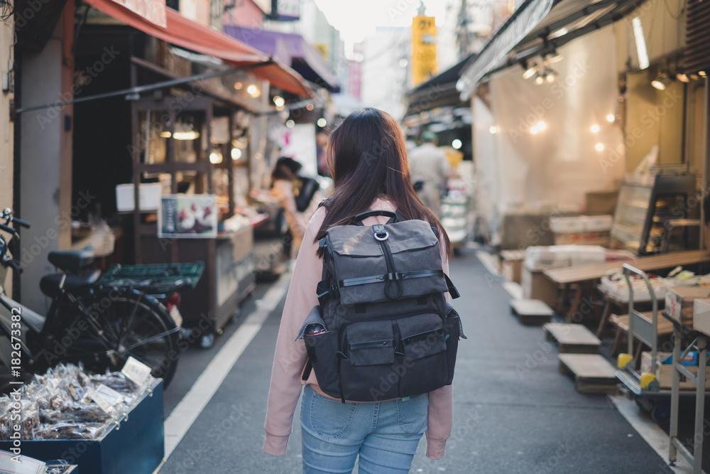 亚洲女子背着背包在老城的市场购物地标度假