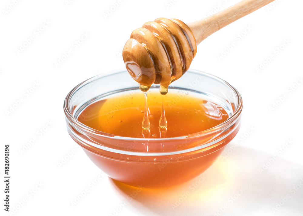 Honey dripping from honey dipper on white background. Thick honey dipping from the wooden honey spoo