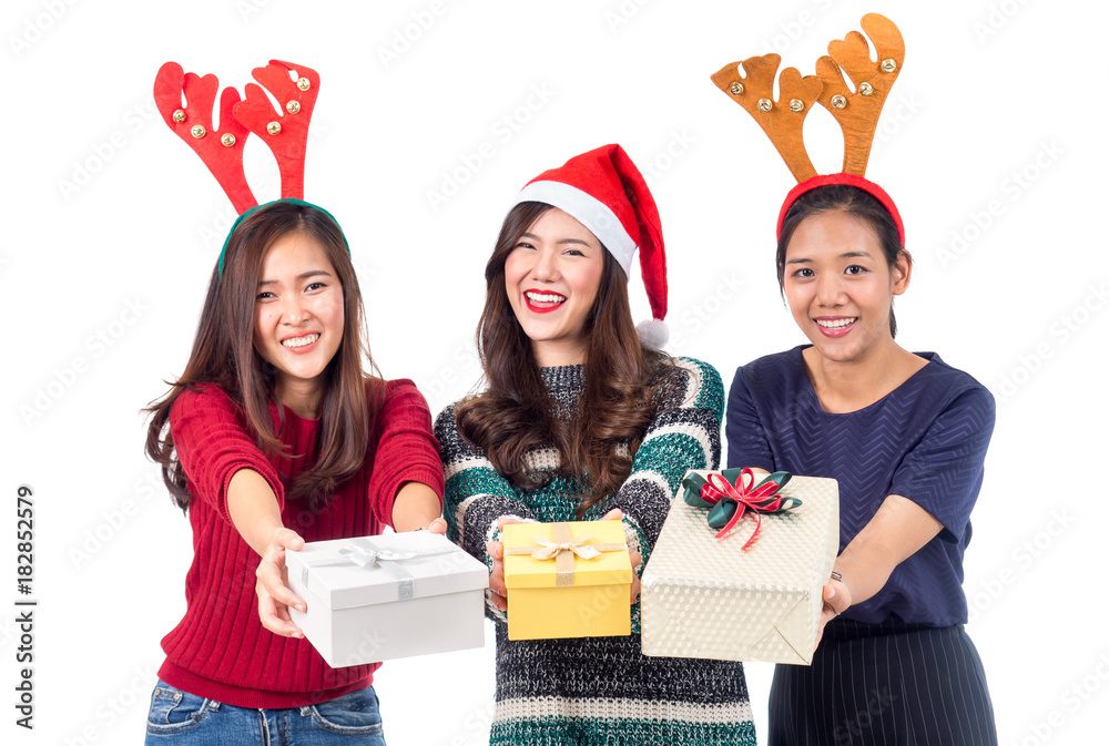 一群年轻快乐的亚洲女人，戴着圣诞老人帽，手里拿着圣诞派对和名人的礼盒礼物