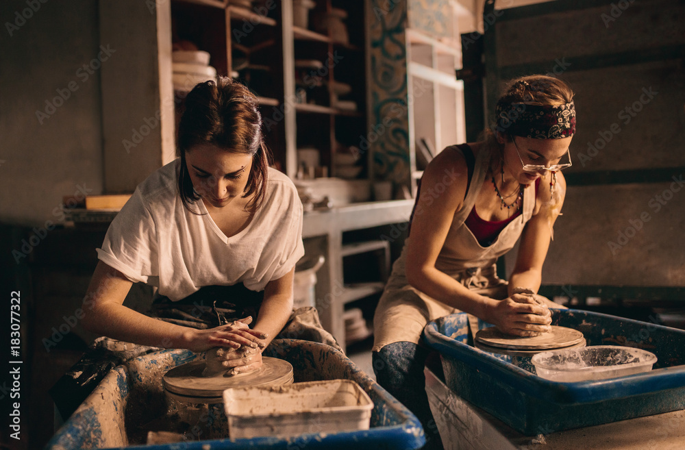 两名妇女在陶器作坊制作粘土壶