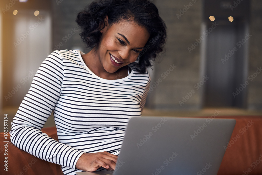 年轻的非洲大学生微笑着使用笔记本电脑