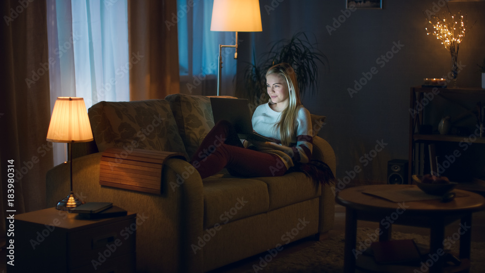 晚上，漂亮的年轻女人躺在沙发上，膝盖上放着一台笔记本电脑。她打字
1101700086,漂亮的年轻女人在客厅用笔记本电脑工作，她坐在沙发上用笔记本o