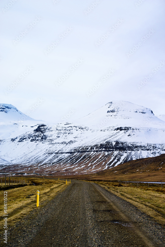 Road through snow-capped mountainous landscape near Kirkjufell, Iceland, Europe.
