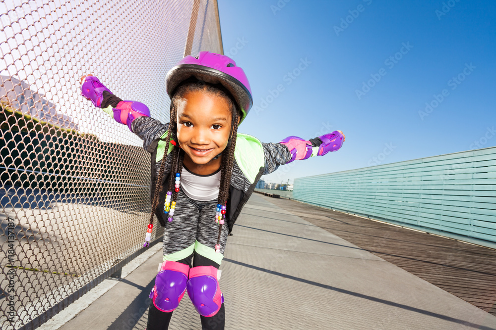 戴头盔的非洲女孩在滑冰公园滑旱冰