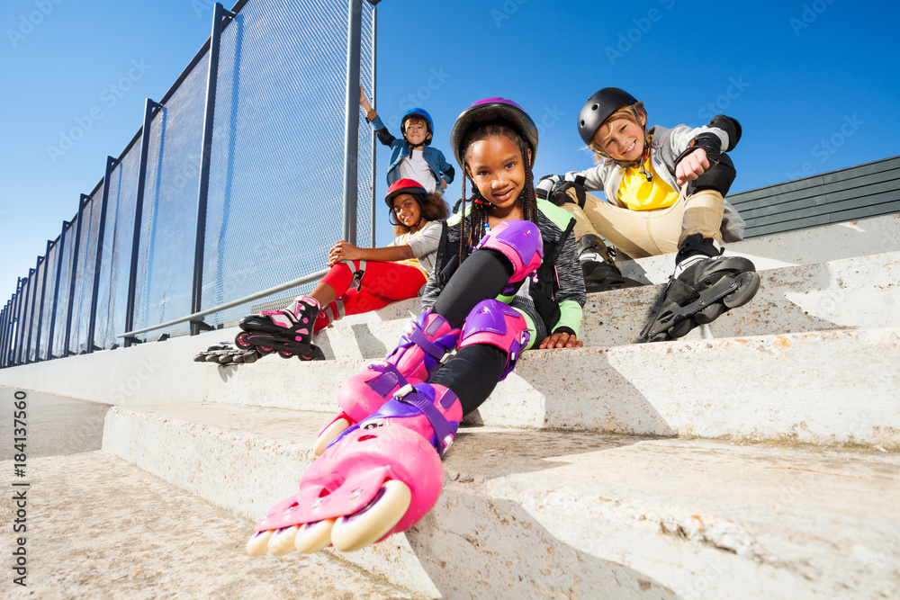 穿着旱冰鞋的女孩和朋友坐在一起