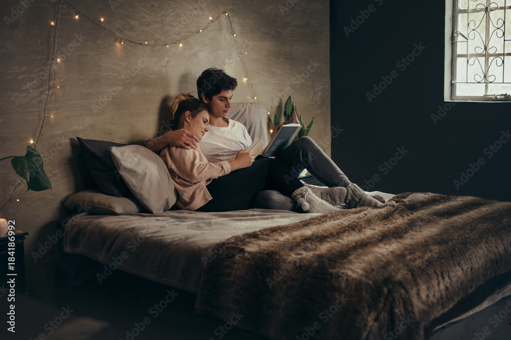 情侣在床上放松，看书