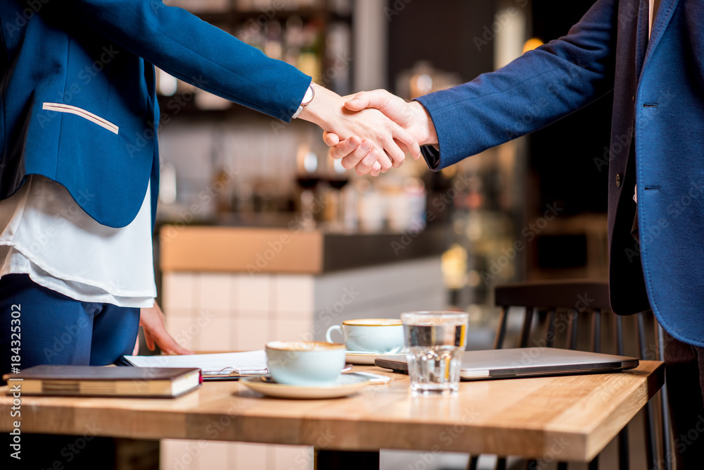 商务情侣在咖啡馆或餐厅握手的特写