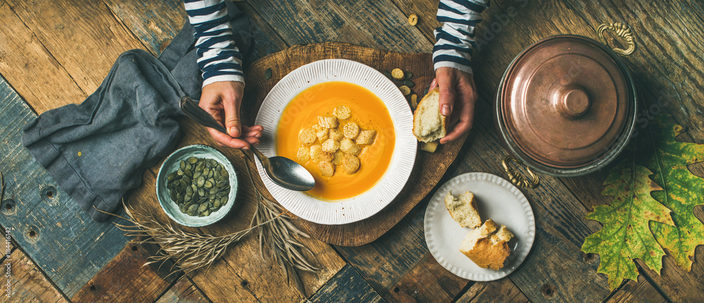 平躺的女性手吃着秋天温暖的南瓜奶油汤，上面有面包块和种子
1456189290,阁楼式厨房