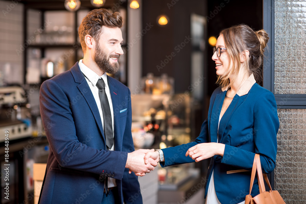 商务情侣在咖啡馆共进午餐时握手