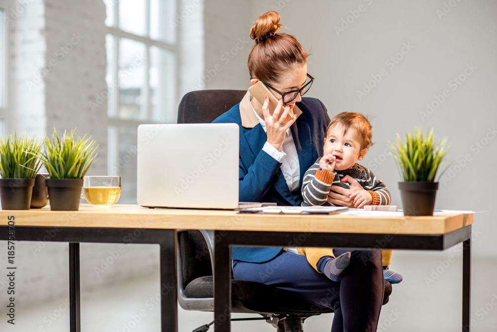 Young multitasking businessmam dressed in the suit working with laptop and documents sitting with he
