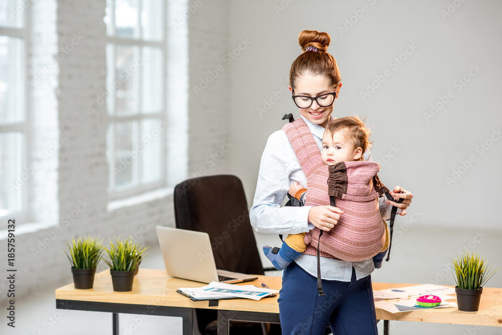 休息时，一位女商人带着她的小儿子站在白色办公室内部的画像