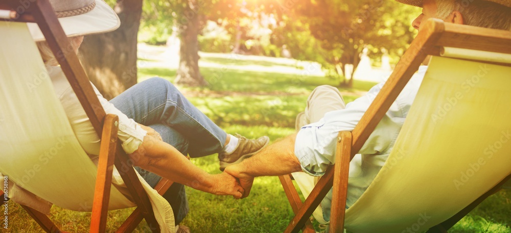 坐在公园躺椅上的成熟情侣