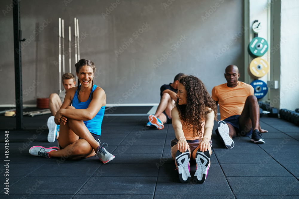人们锻炼后在健身房的地板上一起聊天