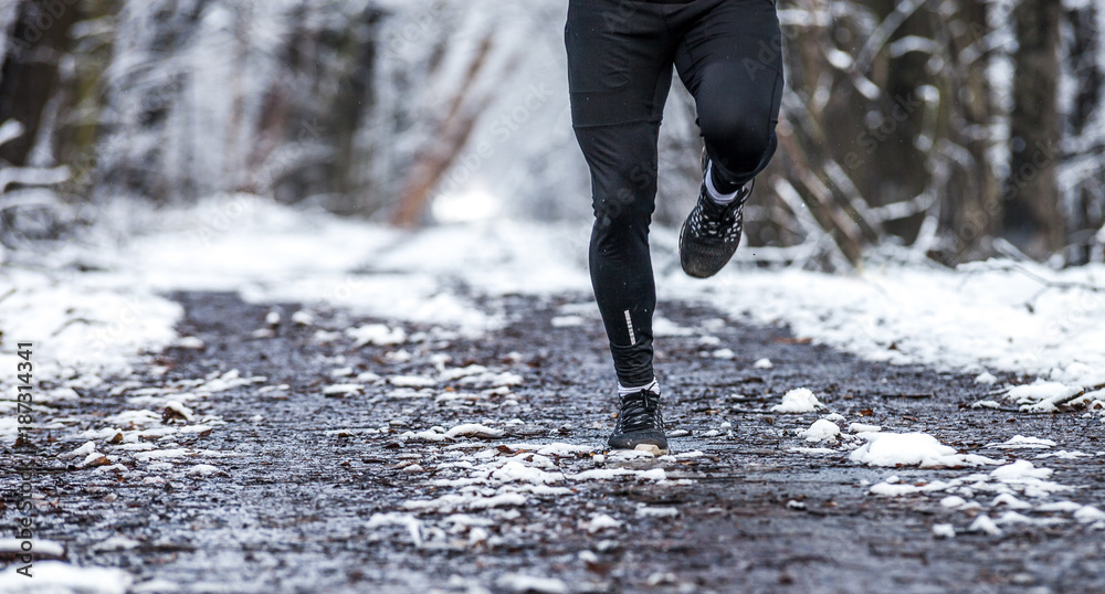 雪地上跑步者的腿，冬季训练的保暖衣服