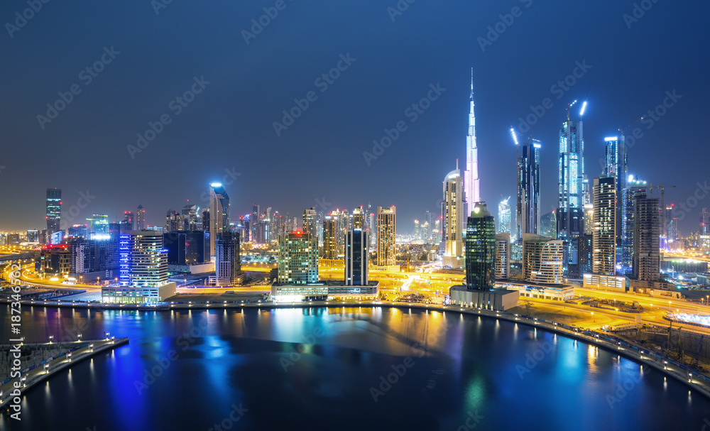 阿拉伯联合酋长国迪拜日落后的迪拜天际线和带海滨长廊的运河