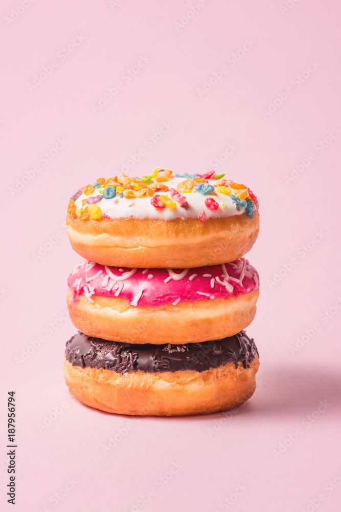淡粉色背景的美味生日甜甜圈。