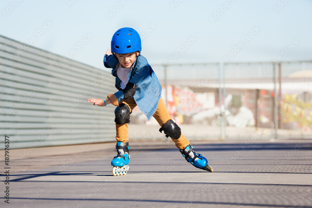 男孩在户外滑冰公园骑旱冰鞋
