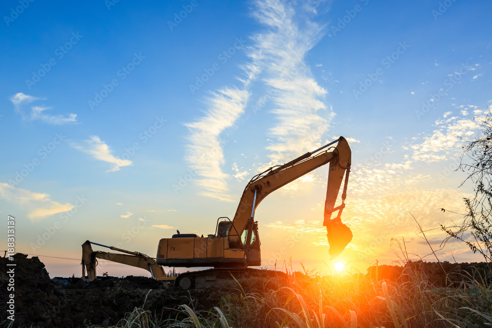 挖掘机在施工现场和日出景观上作业