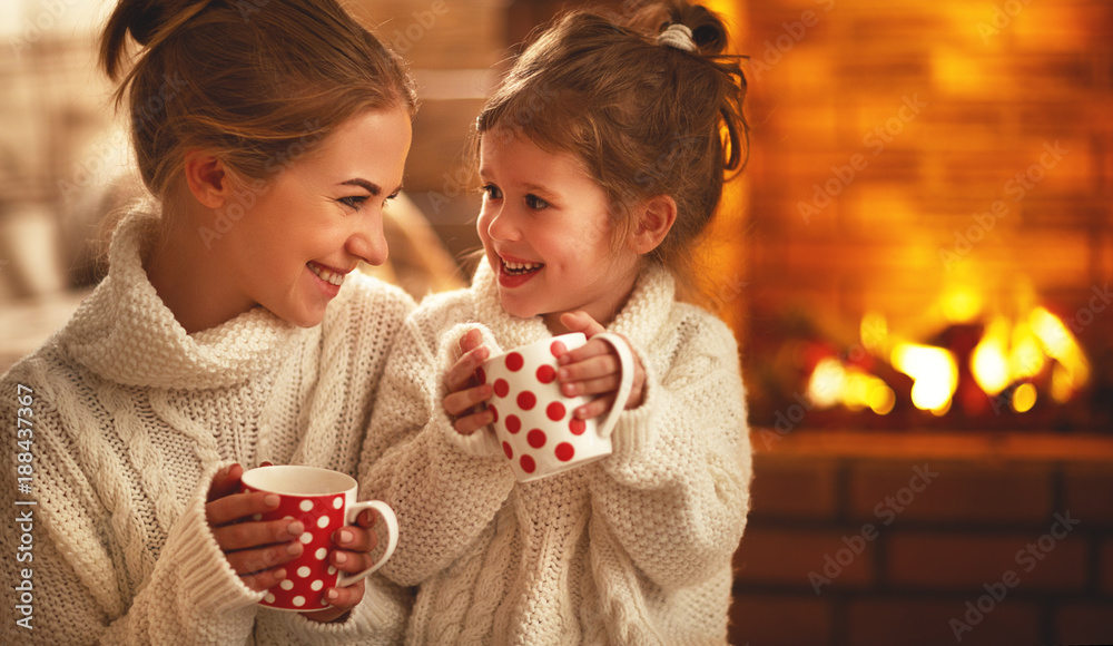 冬天的晚上，家里的母亲和孩子在壁炉旁喝茶大笑。