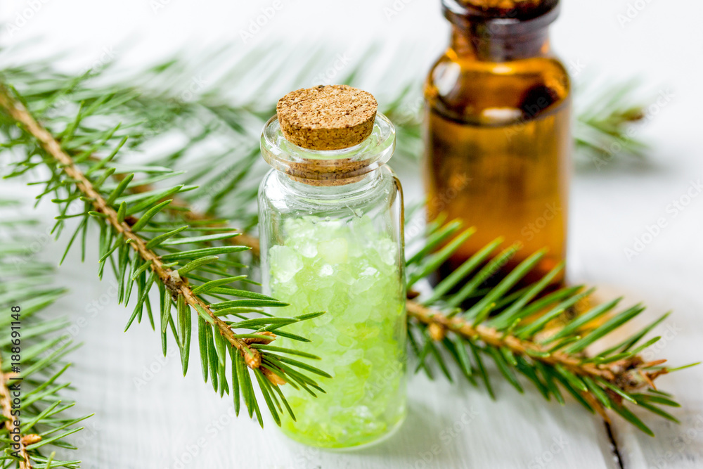 Bottles of essential oil and fir branches for aromatherapy and s