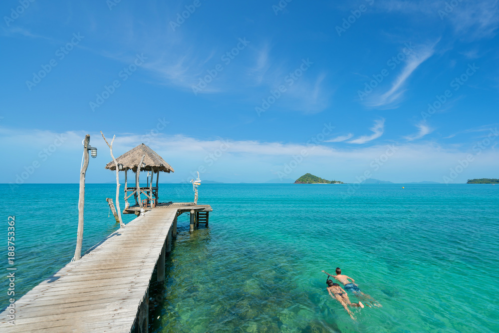 泰国普吉岛热带度假胜地附近，一对年轻的游客在水晶绿松石水中浮潜