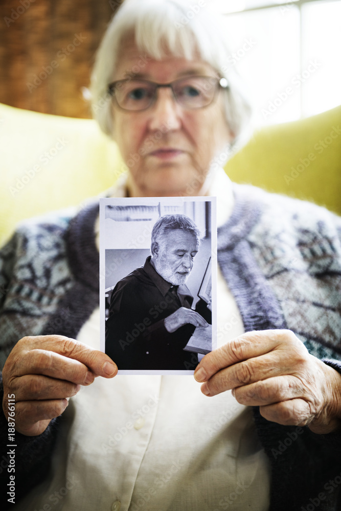 老年妇女拿着一张老年男子的照片