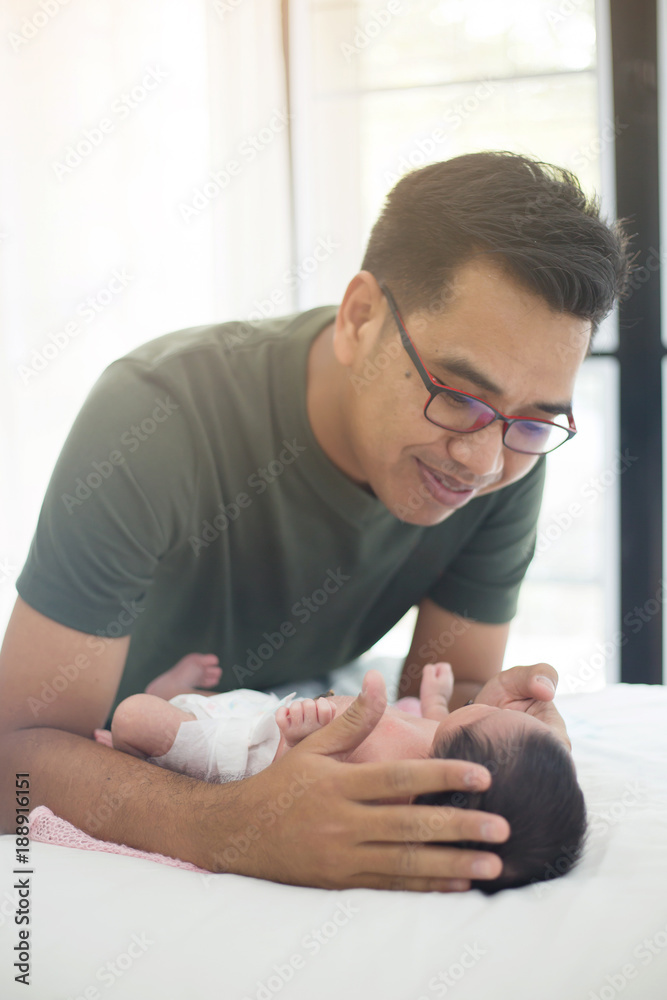 亚洲父亲小心照顾他可爱的新生儿