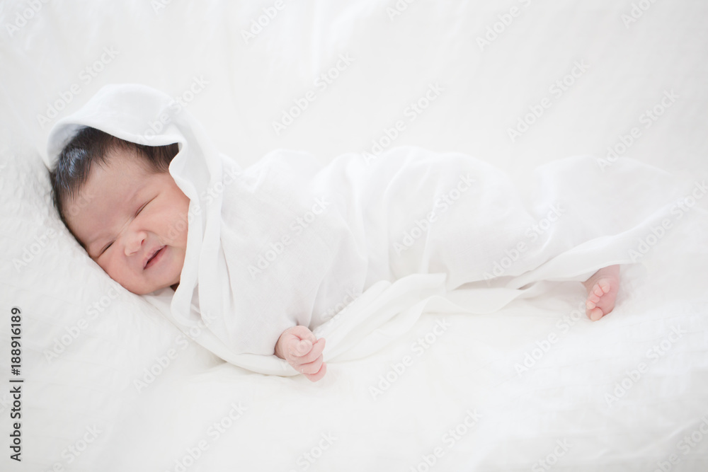 可爱的亚洲新生儿睡在毛茸茸的毯子上
