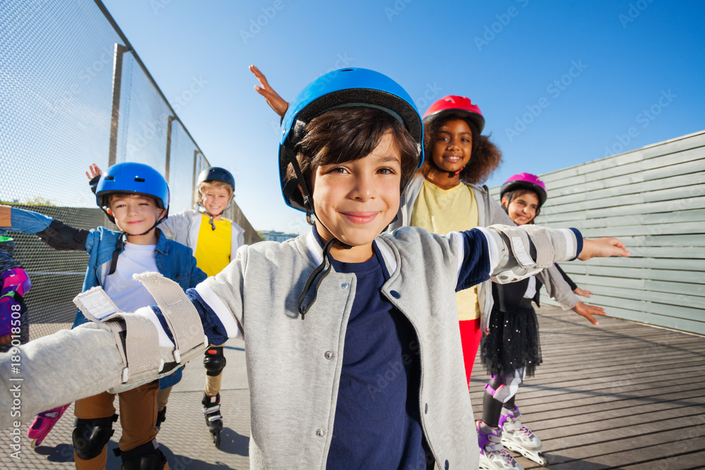 Preteen boy rollerblading with friends outdoors