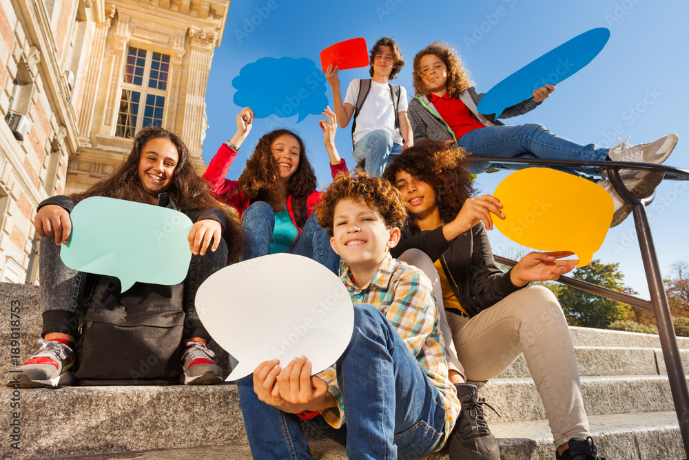 Smiling teenage boys and girls with speech bubbles