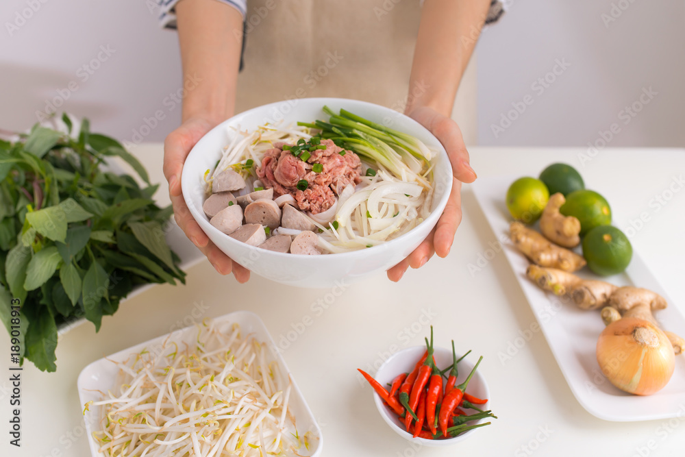 女厨师准备越南传统汤Pho bo，配香草、肉和米粉