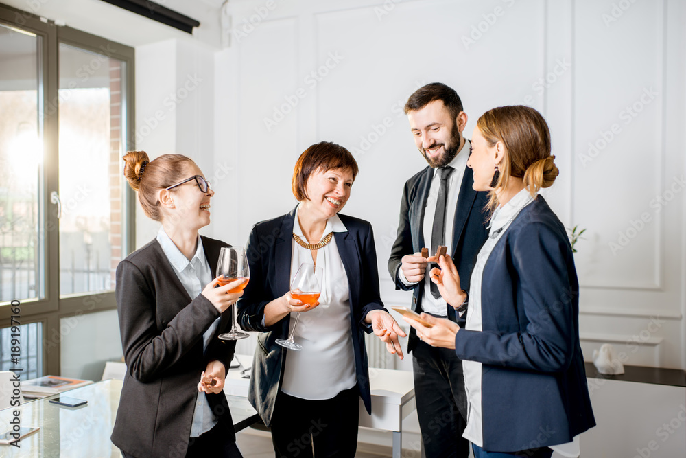 Business people talking during the meeting standing with drinks in the office