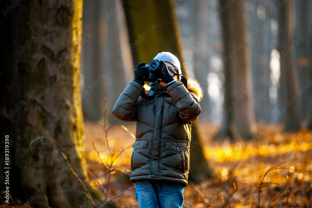 男孩使用数码相机在大自然中拍照，爱好概念