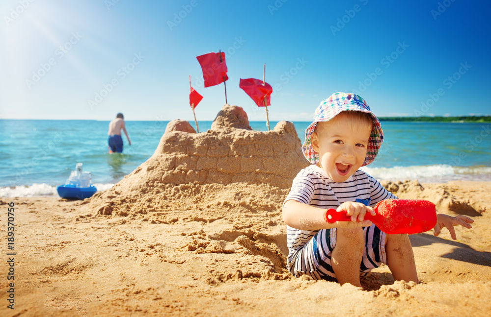 坐在海滩上微笑的男孩